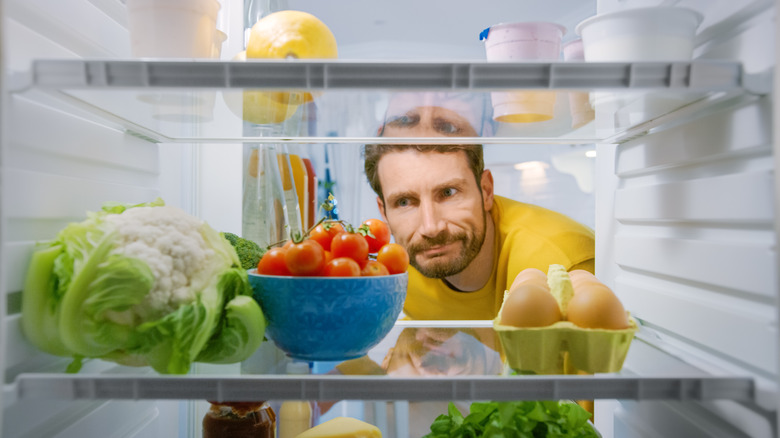 man looking in fridge