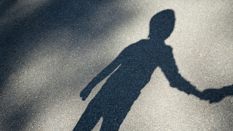 child shadow holding hand