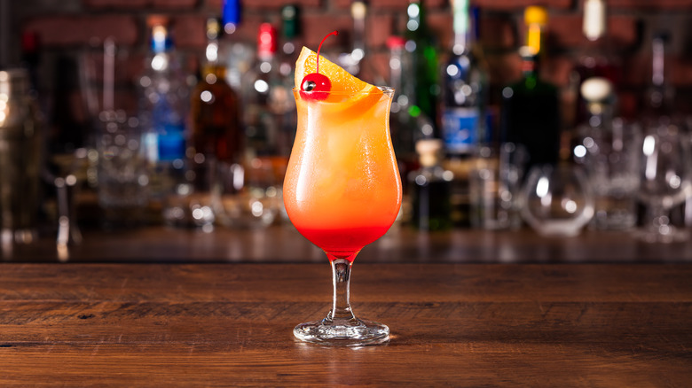 A hurricane cocktail sitting on a table. 