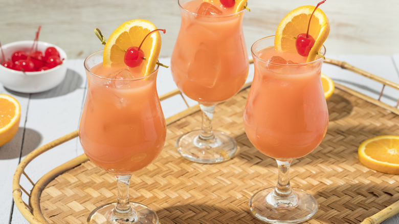 Three hurricane cocktails on a serving tray. 