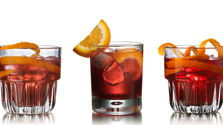 Three negronis in various drinking glasses