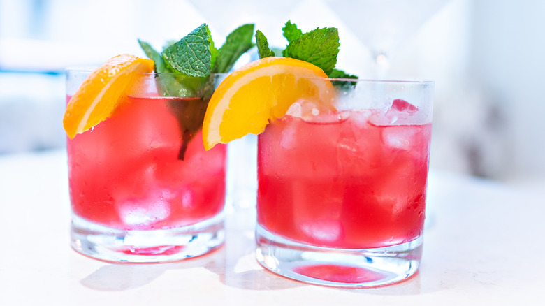 Two cocktails with mint and orange slices