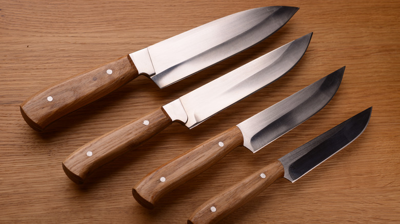 Row of knives on wood table