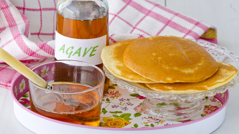 A tray containing pancakes and agave syrup