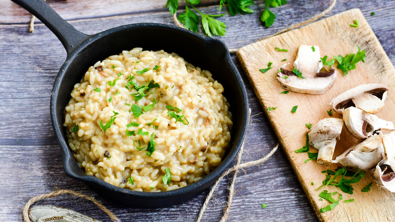 A black skillet filled with mushroom risotto