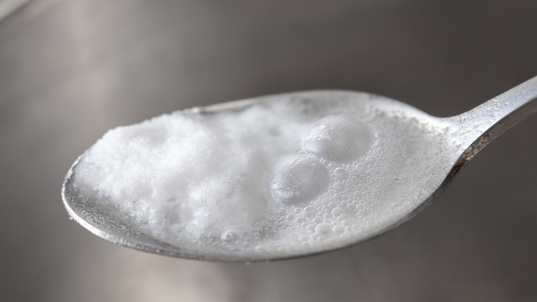 Teaspoon with bubbling white liquid