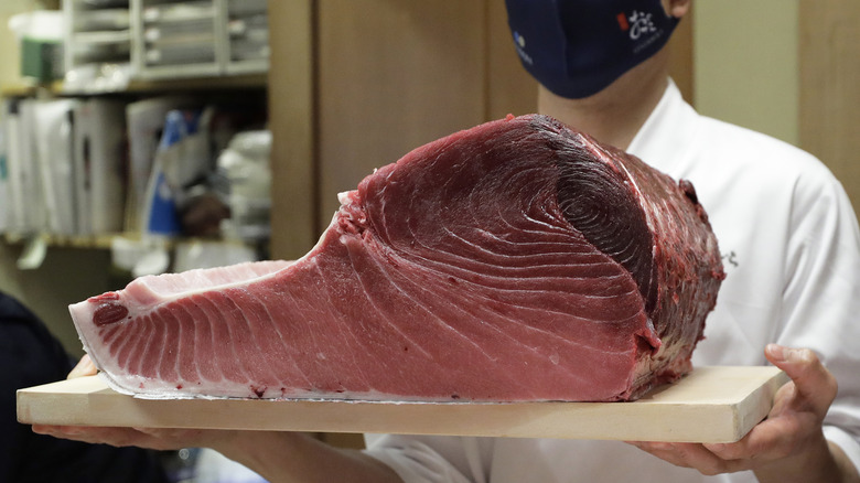 A chef holds a piece of newly-purchased bluefin tuna at a facility of Ginza Onodera sushi restaurant in Tokyo, Japan, on Tuesday, Jan. 5, 2021.