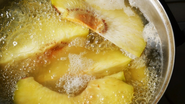 Pot of boiling breadfruit with black background