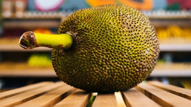 Breadfruit on top of wooden create in front of store shelves