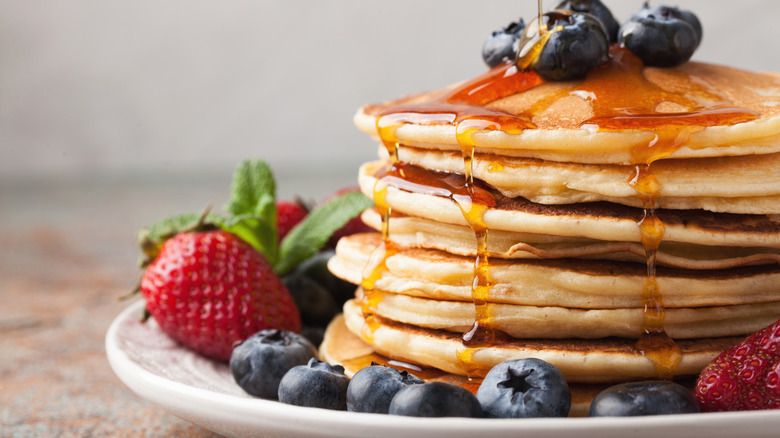 pancakes being drizzled with syrup