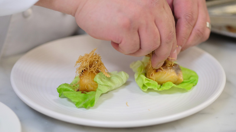 Chef making lettuce wraps with toothpicks