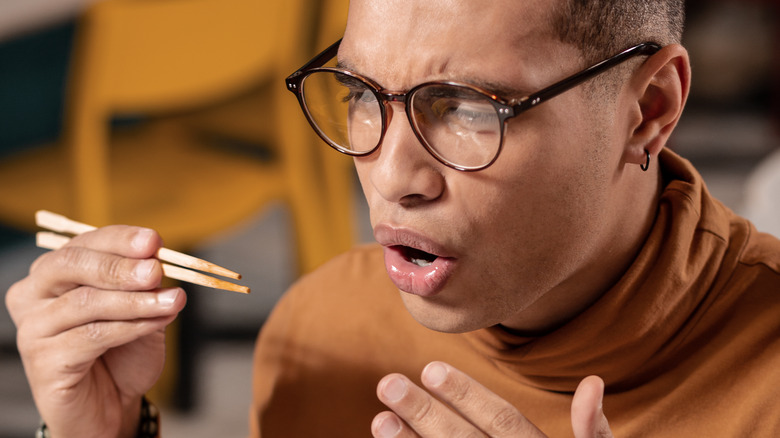 Man reacting to eating spicy Chinese mustard