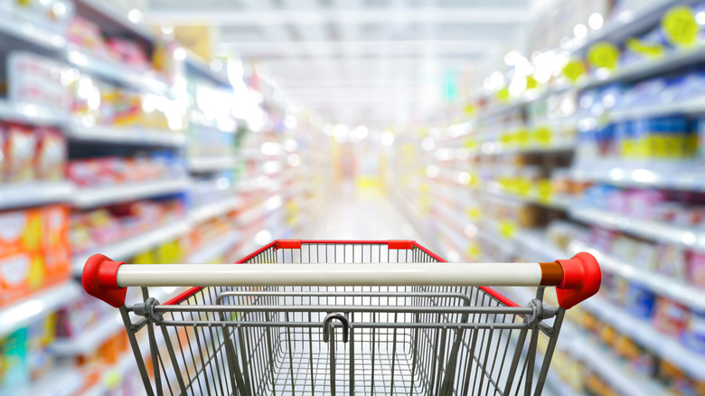 Shopping cart in grocery store aisle 