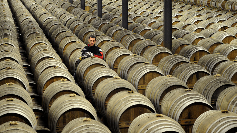 Inspector surrounded by cognac barrels