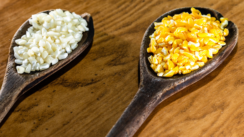 white and yellow hominy on wooden spoons