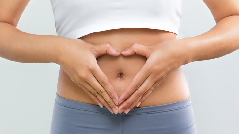 Women making heart shape and belly