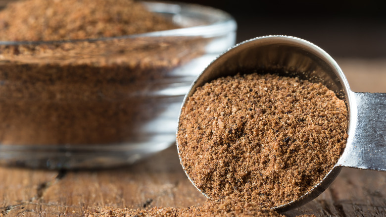 Teaspoon of spices spilling onto board