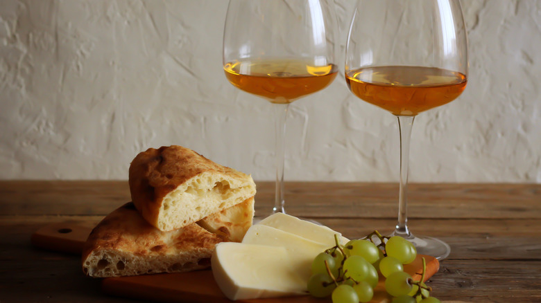 Orange wine with bread, cheese, and grapes