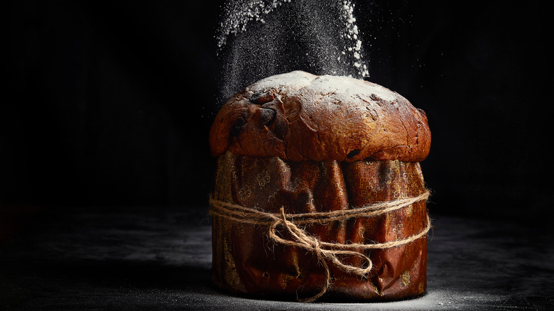 A panettone being dusted with sugar