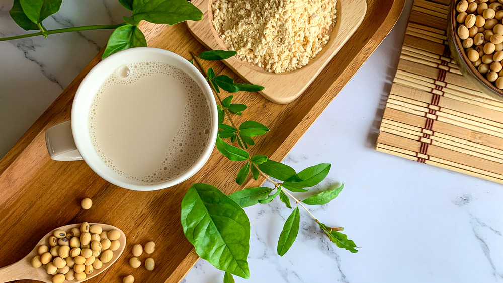 Protein powder and cup of coffee on cutting board