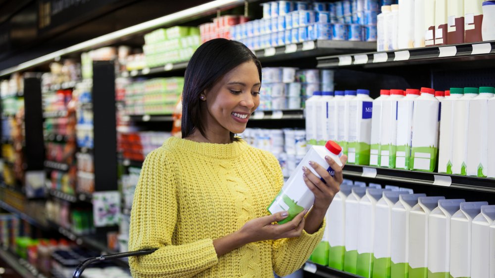 woman looking at a bottle of dairy