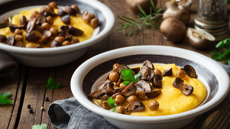 Two bowls of polenta topped with mushrooms