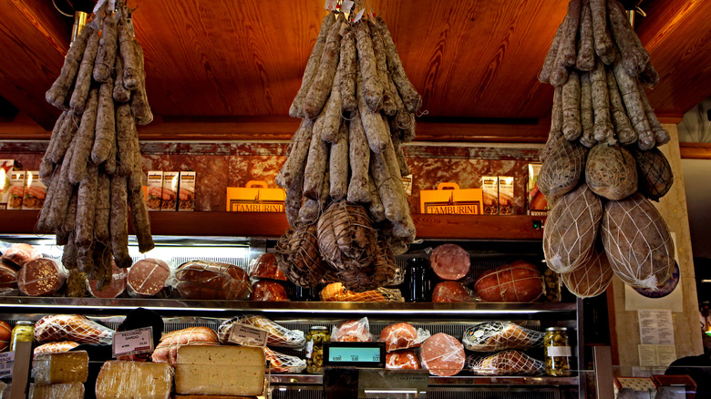 hanging cured meats in butcher shop