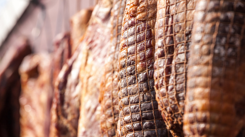 Bound ham legs hanging to dry-age.