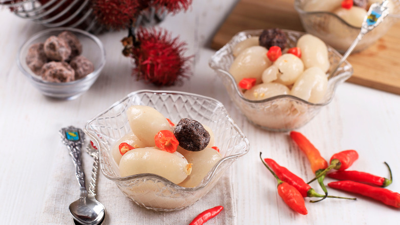 Bowls of peeled rambutans with chilies 