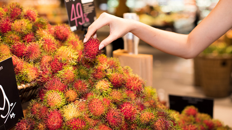 Person picking rambutans from a store