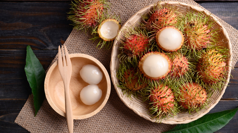 A basket of rambutans next to a bowl of peeled rambutans