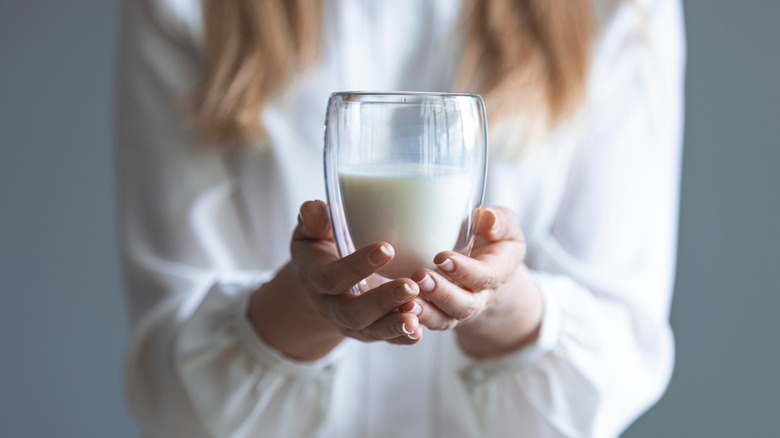 A woman holding a glass of milk