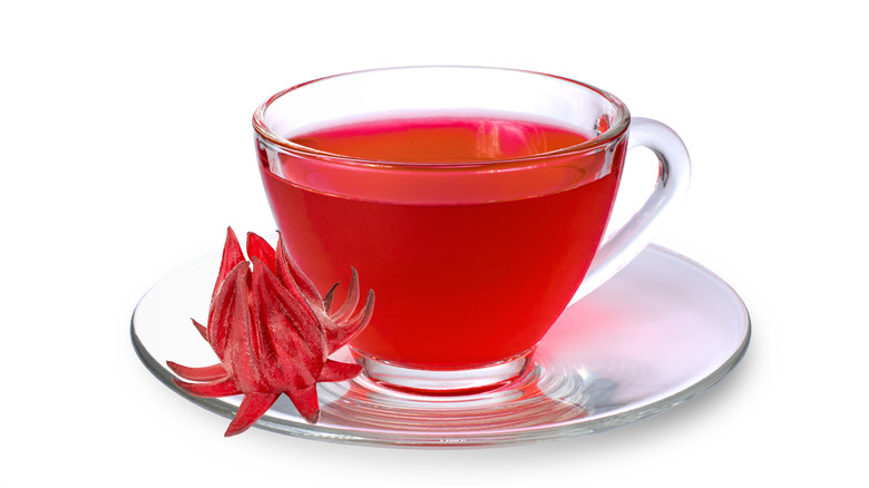 Roselle tea in a clear cup on a saucer