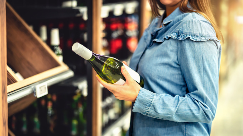 woman buying wine in wine aisle