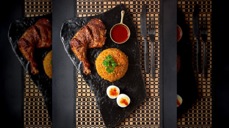 Rice and meat with shito sauce on a black plate