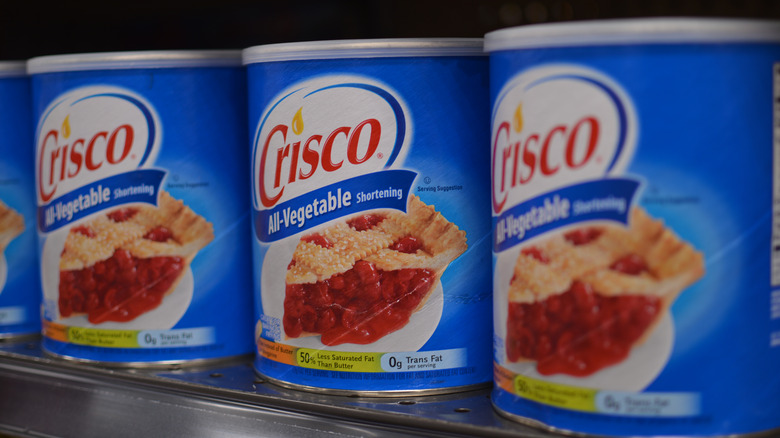 line of Crisco cans on store shelf 