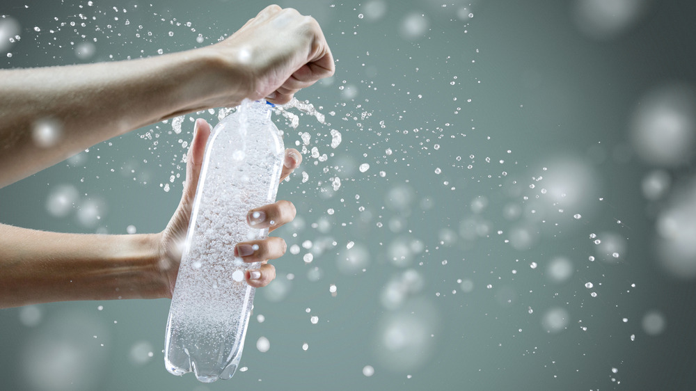 Person opening bottle of carbonated water