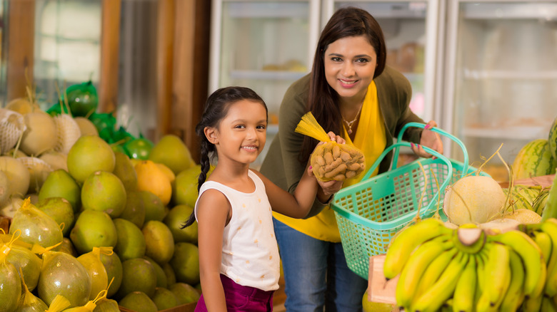 Family buying tamarind in produce aisle