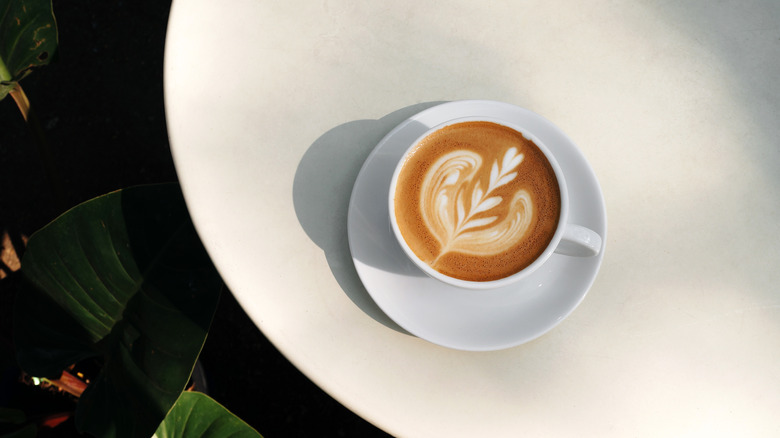 latte art in white mug on white table
