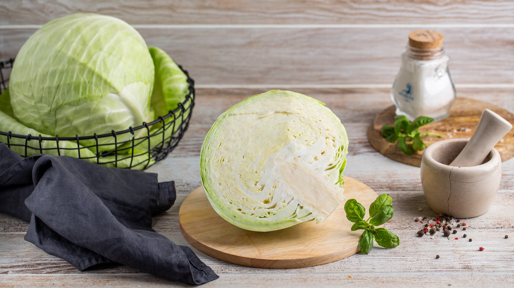 Whole and halved cabbage on counter