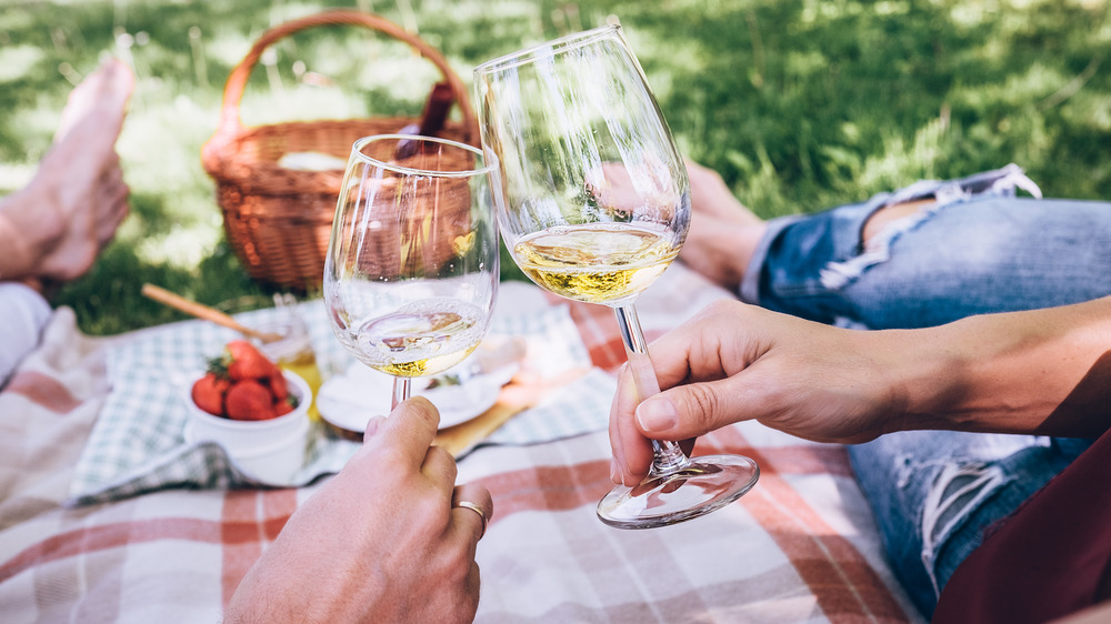 Two people clinking wine glasses