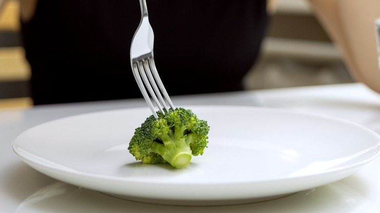 Person Eating Broccoli