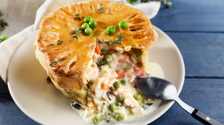 Chicken pot pie on white plate with spoon