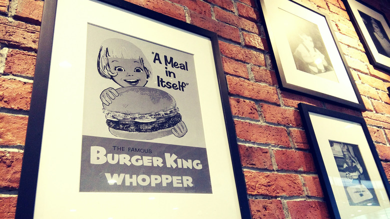 Vintage Burger King ad framed on brick wall