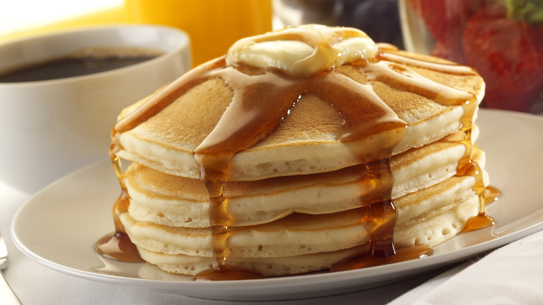 A stack of pancakes with syrup and butter