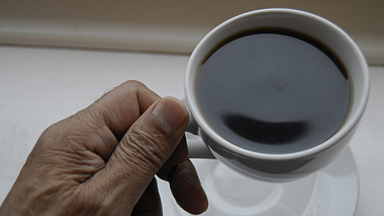 Hand holding a cup of coffee