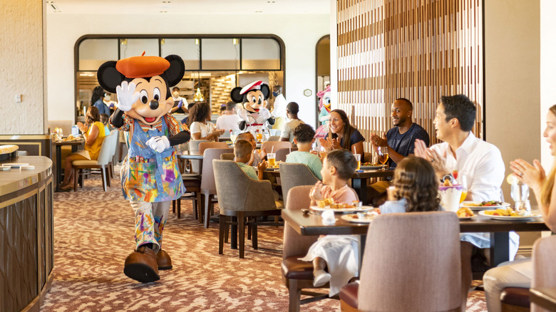 Mickey mouse walking through the dining room during a character breakfast at Topolino's Terrace