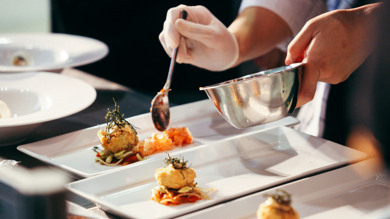 a chef plating several dishes for a tasting