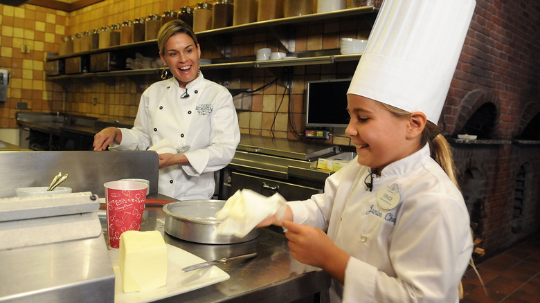 cat cora showing a junior chef how to make a special cake