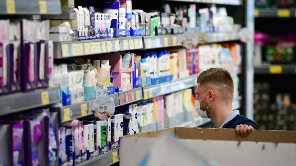 Aldi store employee stocks shelf